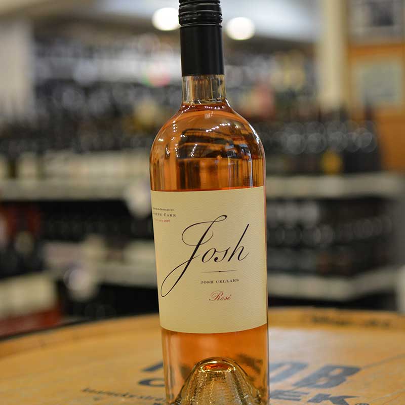 Bottle of rosé wine sitting on a barrel head at Hickey's Wine & Spirits.