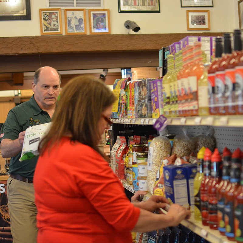 Hickey’s Wine & Spirits staff members restocking the snacks and mixers aisle.