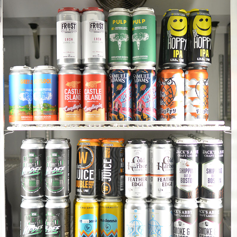 A selection of beers behind glass in coolers at Hickey's Wine & Spirits.